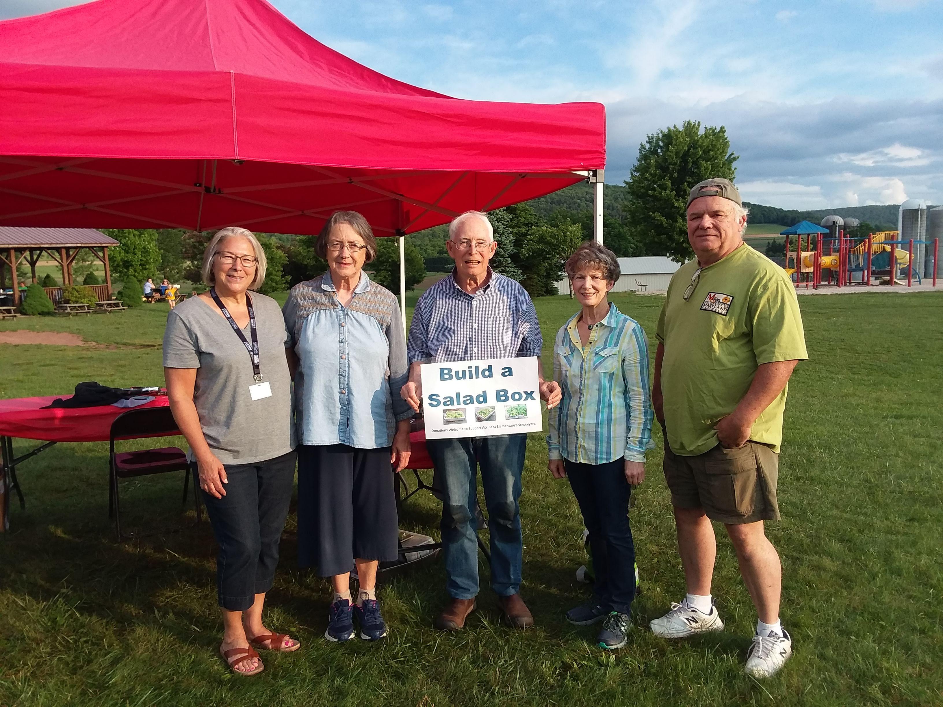 master gardener participants in front of red outdoor tent