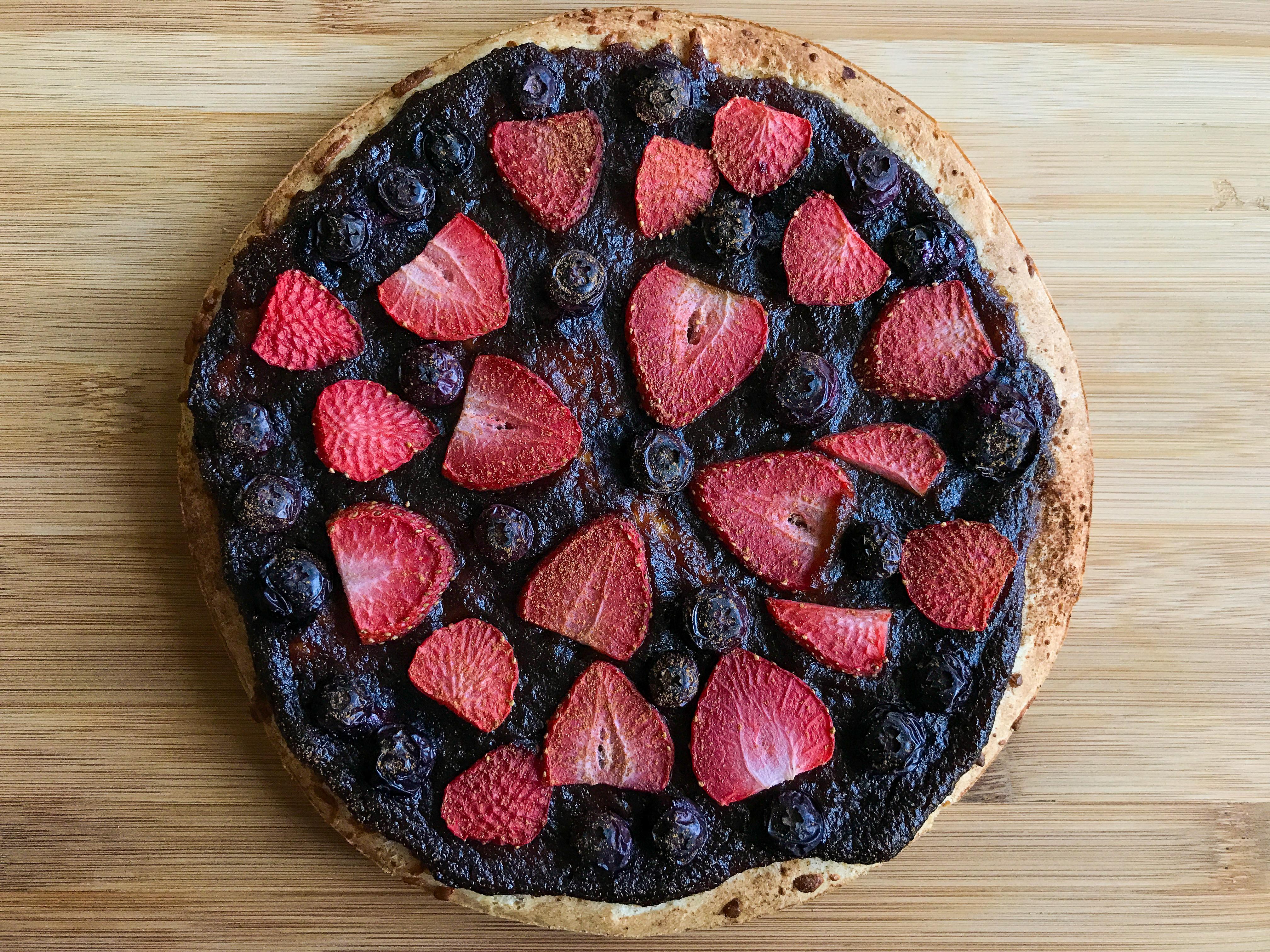 Strawberries and blueberries in a circle shaped like a pizza.