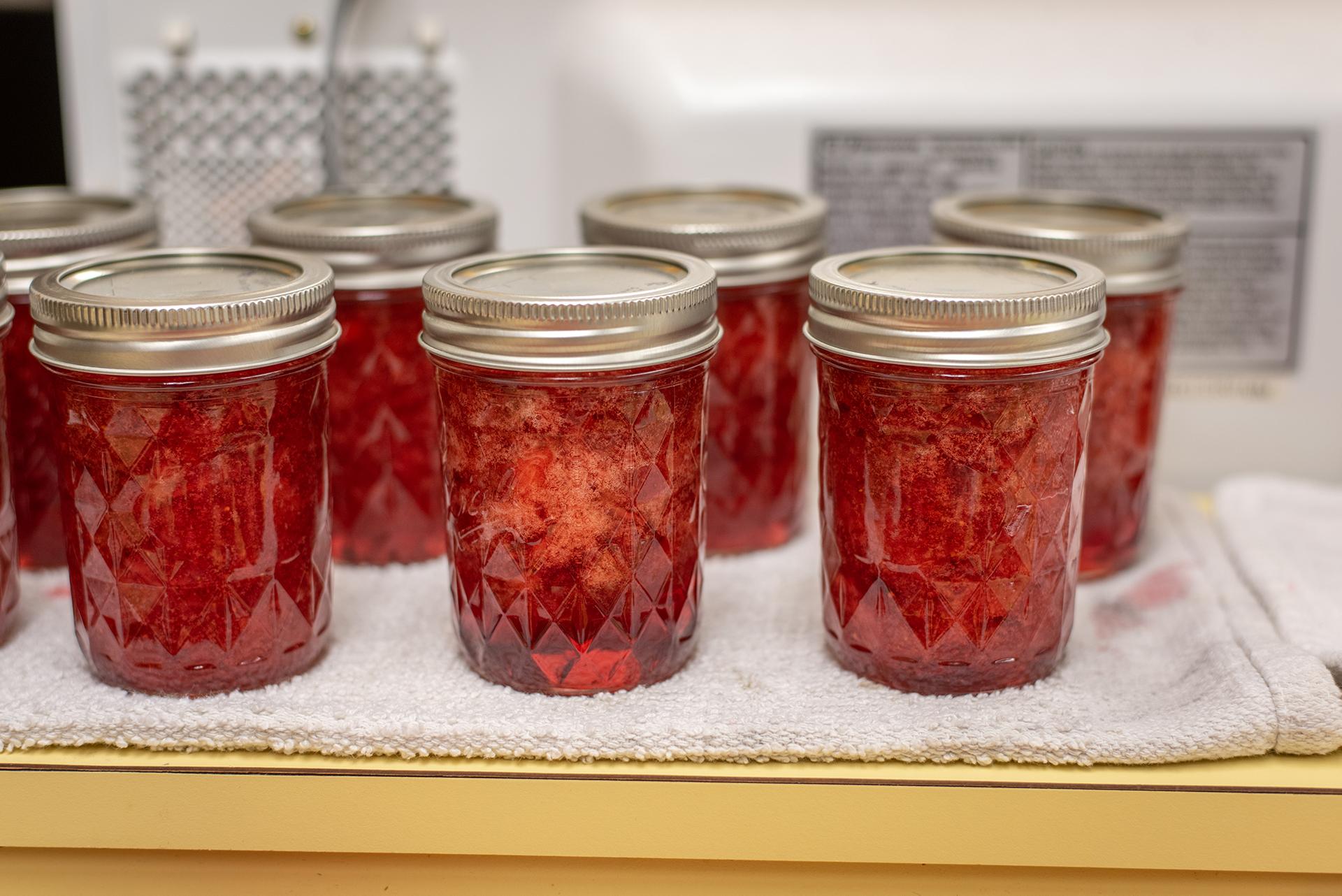 Jars of red jam on a white table