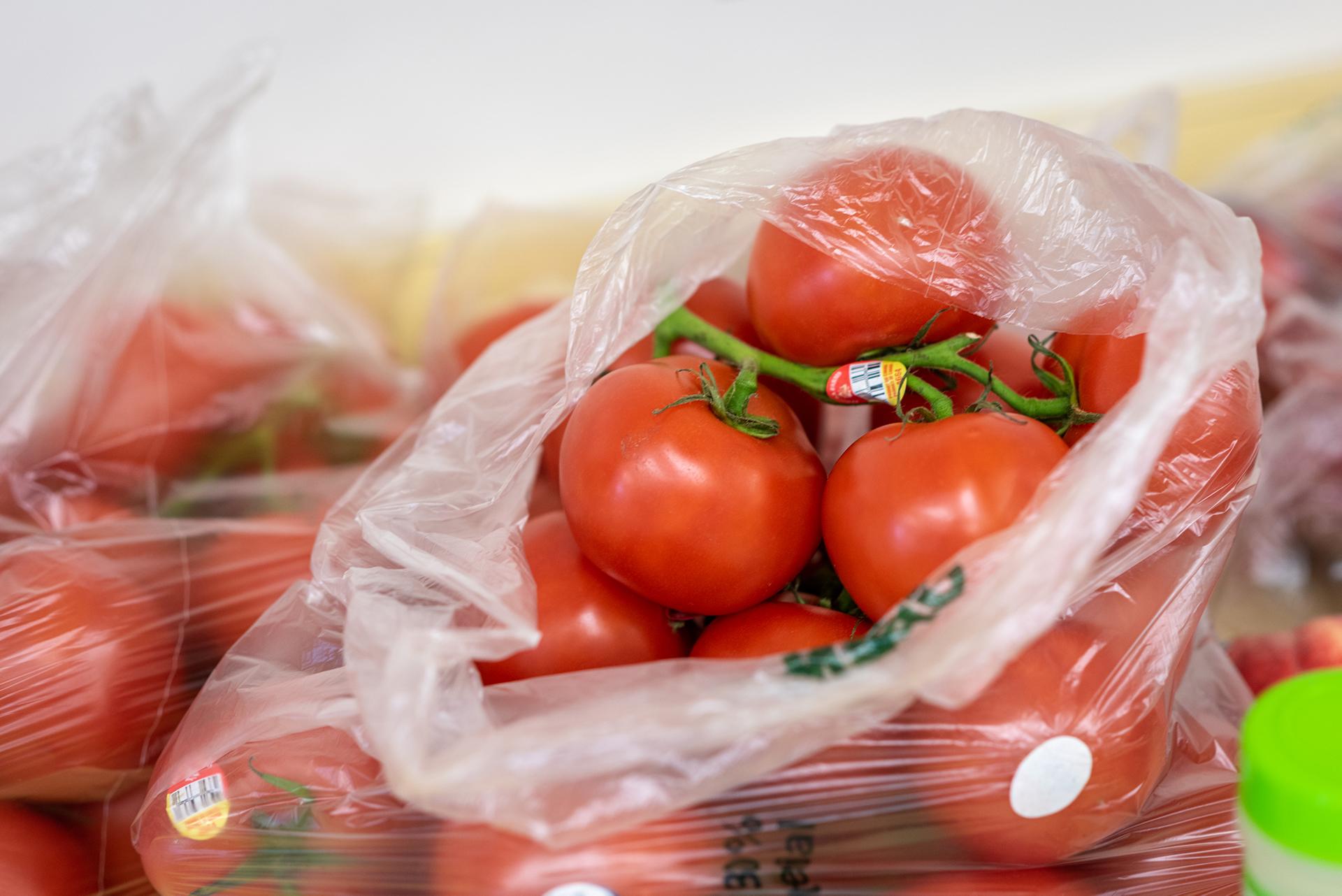 Plastic bags filled with red tomatos