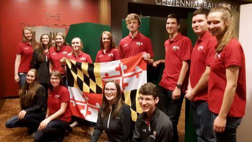 Youth on a national trip holding the Maryland state flag