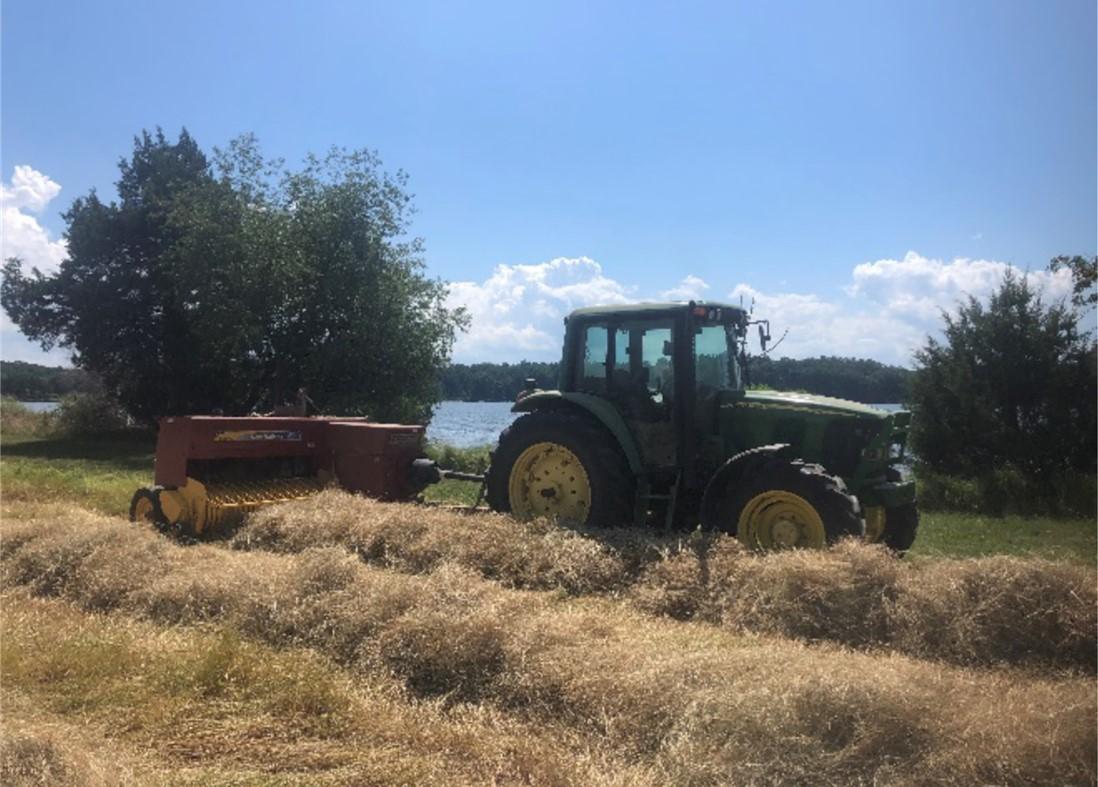 Farm tractor bailing hay