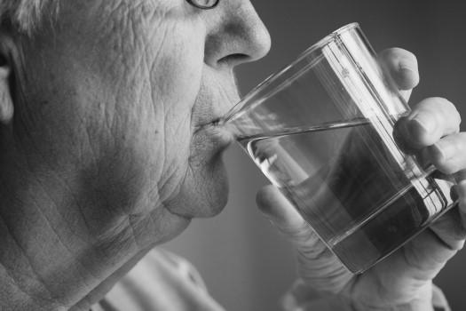 Side view of elderly woman drinking water