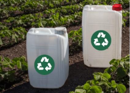 Pesticide containers for recycling sitting in a field of crops
