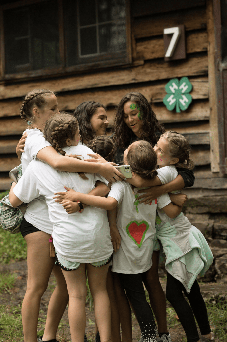 Group of Campers Hugging in front of Cabin