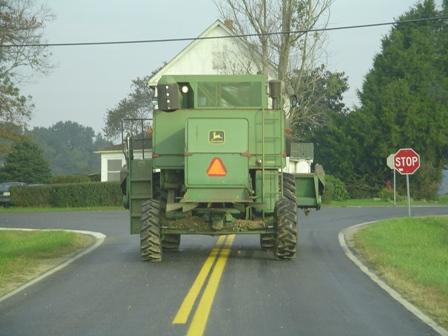 Farm equipment driving on a state road.
