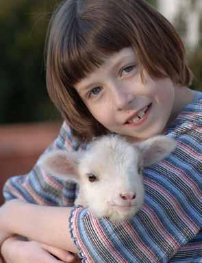 Little girl holding a lamb. Photo: Edwin Remsberg