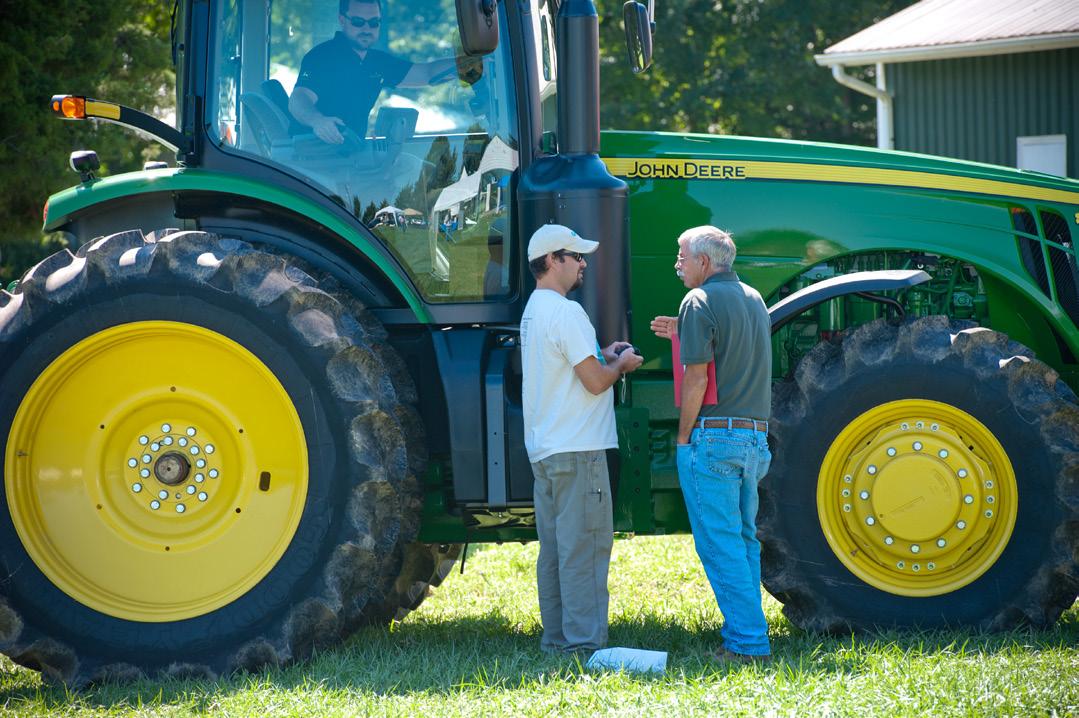 Two men talking next to a parked tractor, Photo: Edwin Remsberg