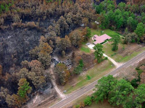 Aerial photo of wildfire aftermath, with one structure burned and one mostly untouched. Photo by Virginia Dept. of Forestry