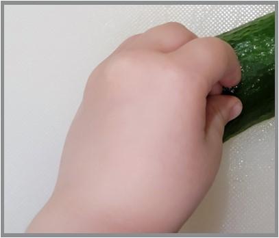 Hand demonstation on how to hold produce properly by curling fingers into a "C" shape.
