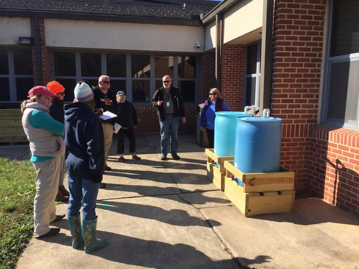 Linda has always been fascinated by the “why” of many things and is seen here inspecting a rain barrel hook-up during a WSA class tour.