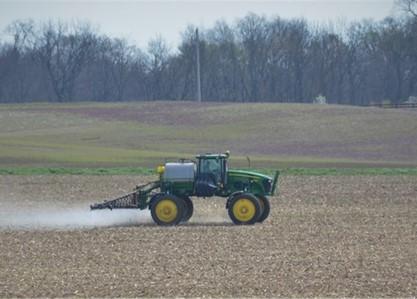 Tractor spraying herbicide on field