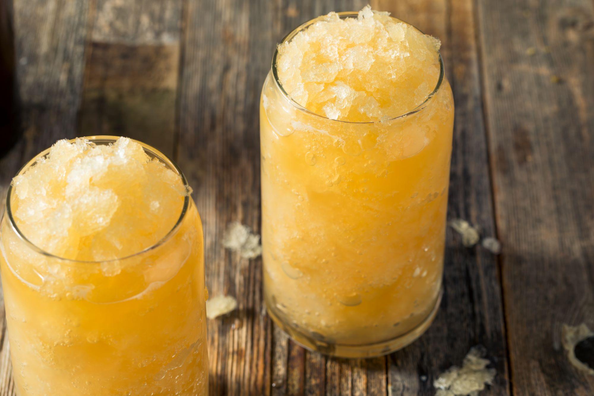 Two glasses with orange frozen fruit juice.