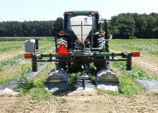 Tractor spraying on field with cover crops