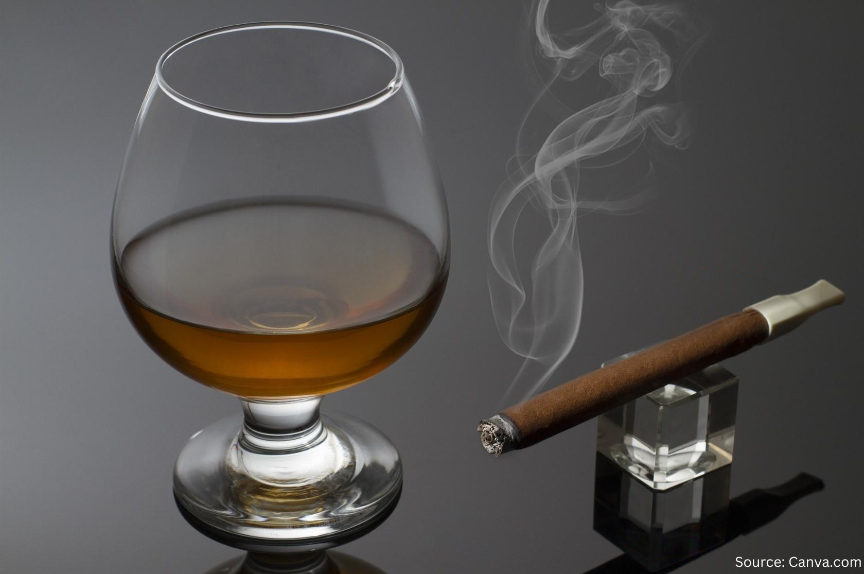 A brandy snifter and a smoking cigar.
