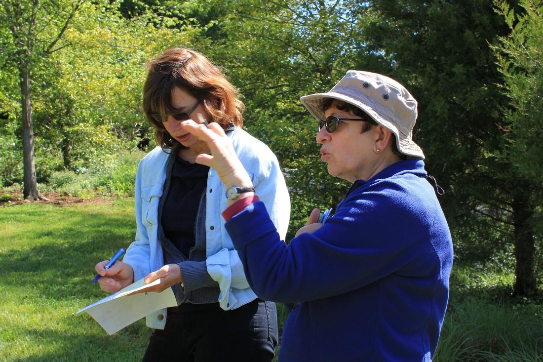Bay-Wise Team Leader, Ellen, talks about natives and homeowner, Robin takes notes.