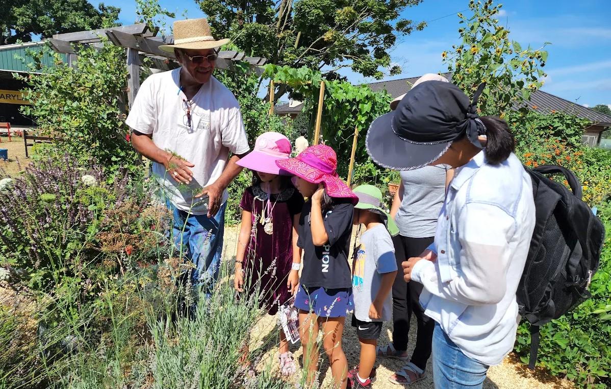 A Master Gardener volunteer teaches visitors to a demonstration garden.