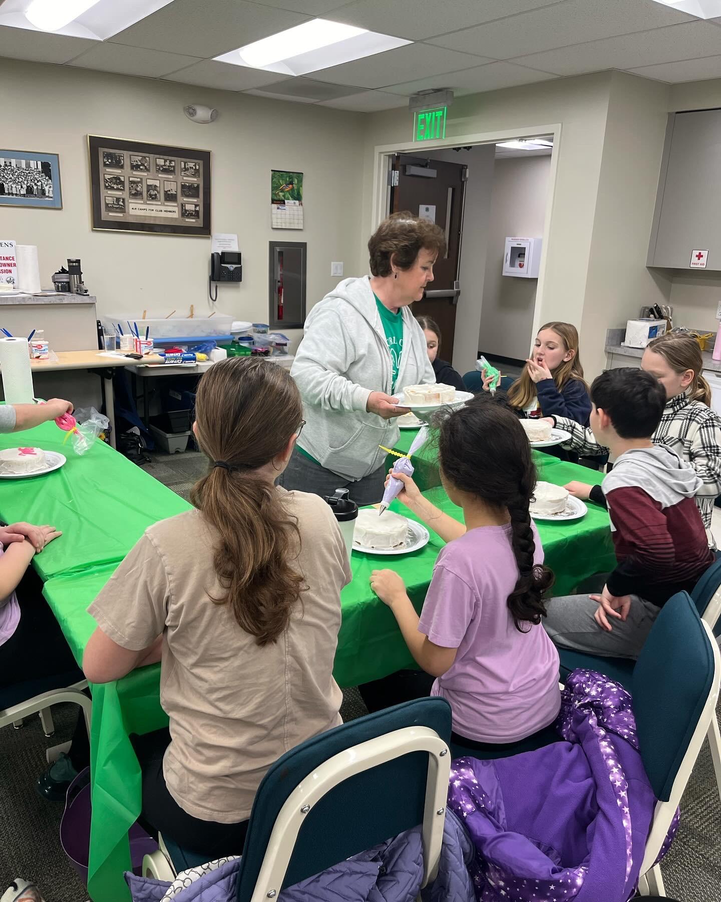 4-H children sitting around a table while educator speaks