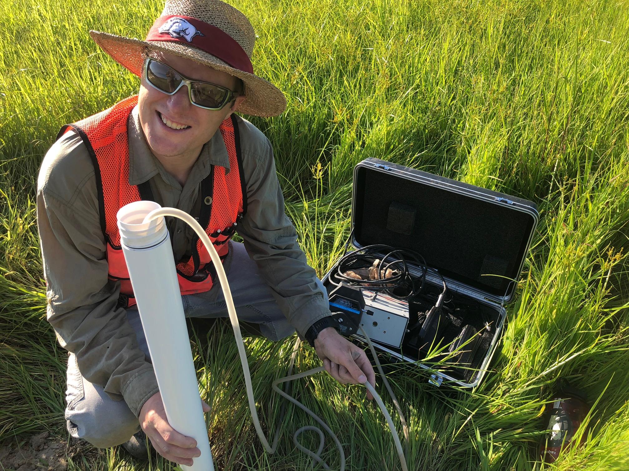 researcher collecting water samples in the marsh 