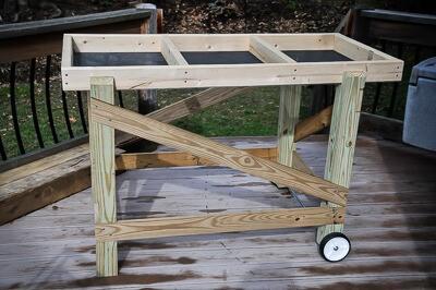 Salad Table augmented with straight and angled cross braces and wheels at one end.