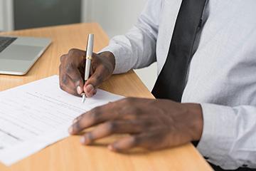  A person signing a document, showing only hand and paper.