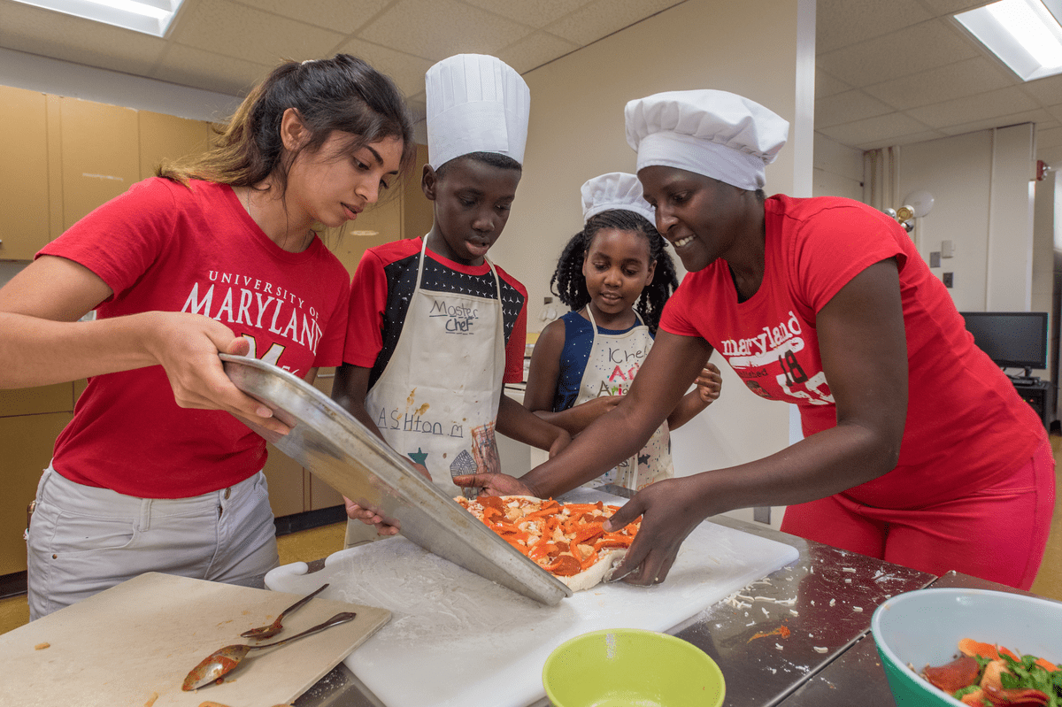 Kids learning how to make pizza