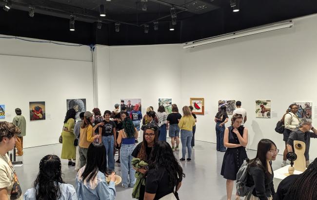 A photo of people attending a past exhibition inside the Herman Maril Gallery.