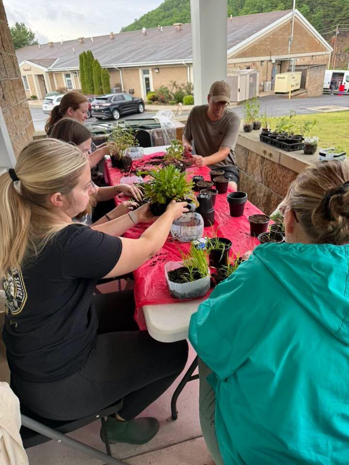 several people at a table doing winter sowing in milk jugs 