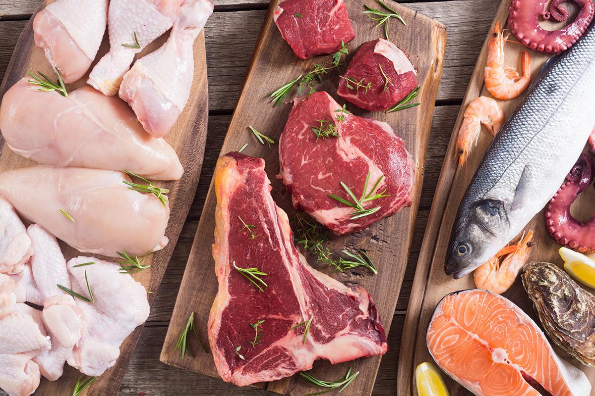 A variety of cuts of raw meat including beef, chicken, and fish