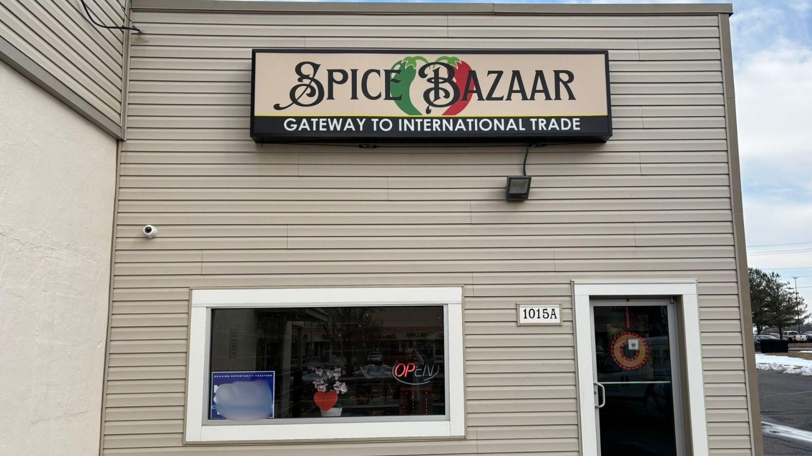 spice bazaar sign on storefront, window and door seen and sliver of a parking lot