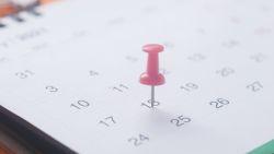 calendar on a white background with a red push pin on the date marked 18th